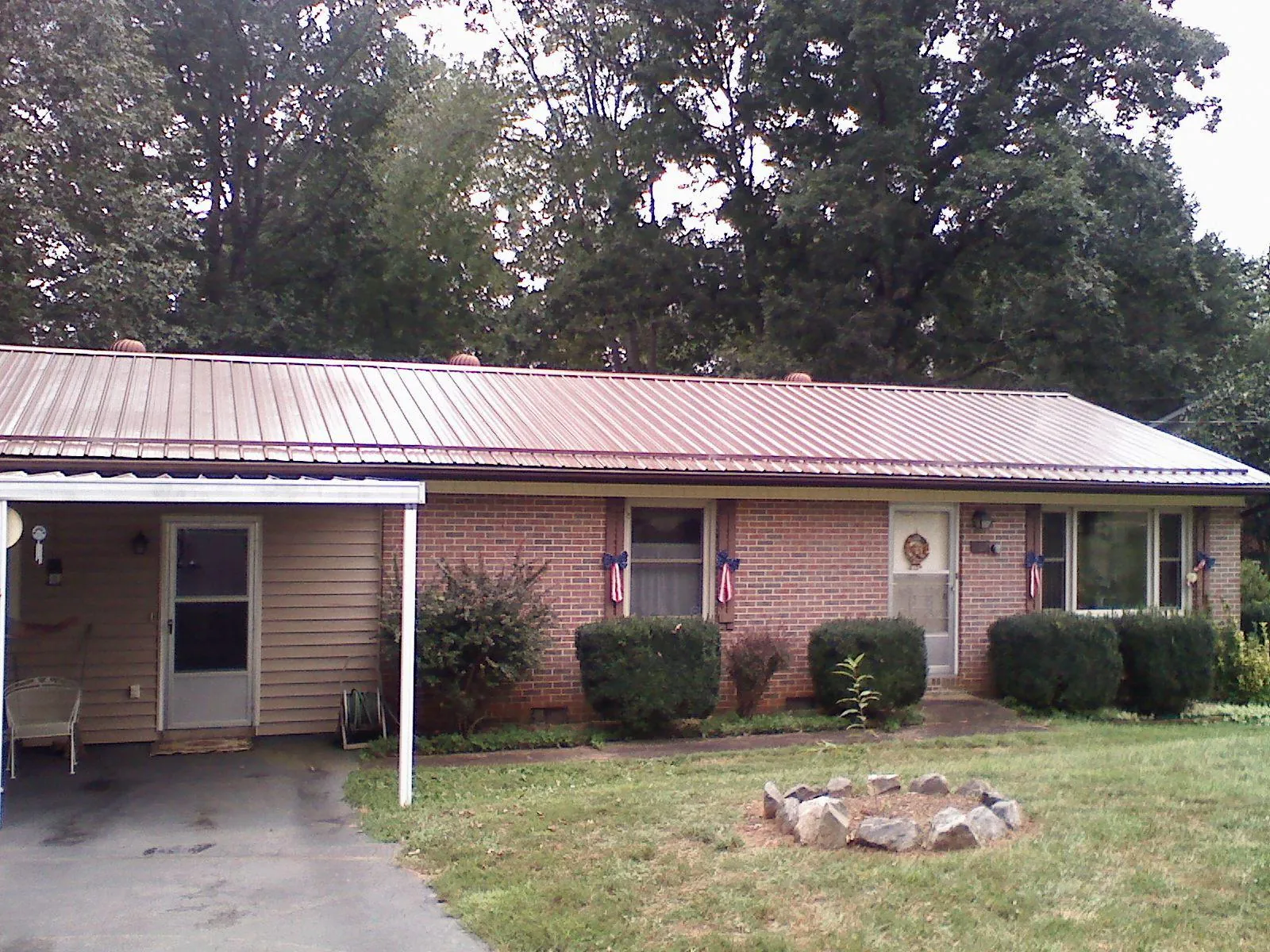 Bronze metal roof and carport on a brick ranch home — Roof Repair work by our crew in Carmine