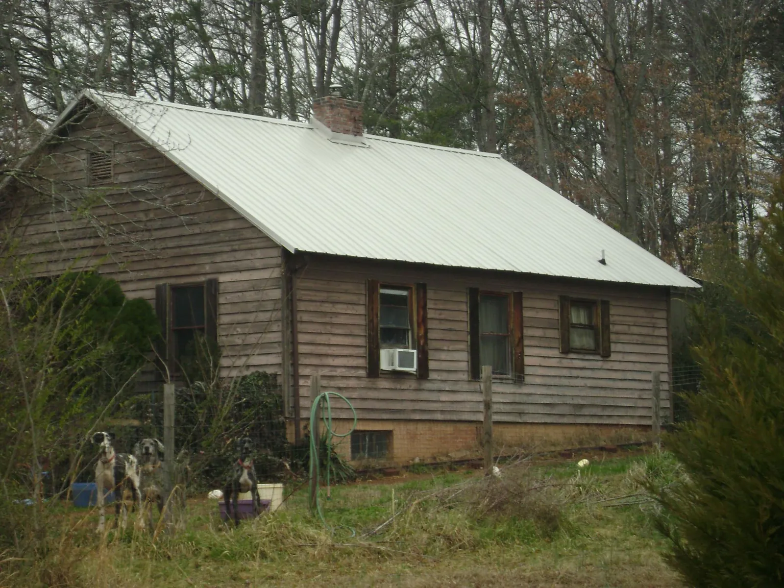 White metal roof on an old wood sided farmhouse, from a Metal Roof Installation job in Carmine